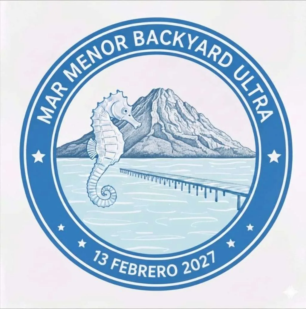 Emblema circular en tonos azules del Mar Menor Backyard Ultra: un caballito de mar sobre el agua, con un pontón de madera y una montaña al fondo, rodeado por los rótulos «MAR MENOR BACKYARD ULTRA» y «13 FEBRERO 2027» entre estrellas.